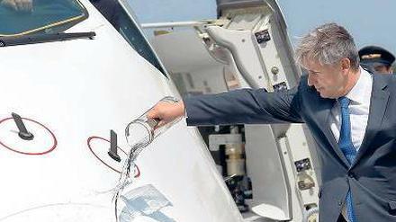 Pitschnasser Vogel. Wowereit kippte am Dienstag Wasser auf den A 380. Das passte zu der etwas bizarren Taufe, denn eigentlich sollte sie ja zwei Tage vor der großen Eröffnungsfeier in BER stattfinden. Es kam bekanntlich anders. Foto: dpa/Wolfgang Kumm