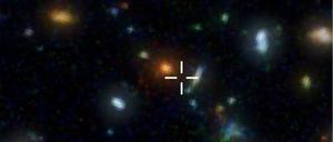Ganz weit draußen. Das Bild zeigt einen Ausschnitt aus dem Hubble Deep Field mit vielen, weit entfernten Galaxien. Die Submillimeter-Galaxie HDF 850.1 befindet sich an der markierten Stelle. Im optischen Bereich ist sie allerdings nicht sichtbar. Sie lässt sich nur mit Radioteleskopen nachweisen.