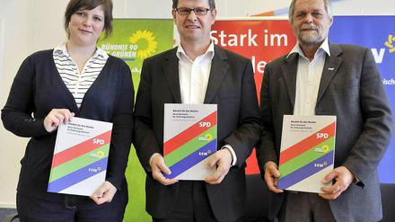 Geschafft: Flemming Meyer vom SSW (rechts), der Landesvorsitzende der SPD, Ralf Stegner, und Grünen-Landesvorsitzende Marlene Loehr halten den Koalitionsvertrag in die Kameras.