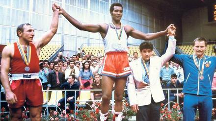 Olympiasieger. Auch 1980 gewinnt die kubanische Box-Legende Teofilo Stevenson in Moskau die Goldmedaille – zum dritten Mal hintereinander. Auf dem Bild neben ihm stehen Pyotr Zaev aus der ehemaligen Sowjetunion und der Ostdeutsche Jürgen Fanghänel, der für die DDR Bronze gewann. Foto: AFP