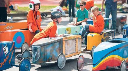 In der Boxengasse. Am Sonntag wurde der Mehringdamm wieder zur Rennpiste. Mit rund 35 km/h sausten die Fahrer, immer im Dreier-Pulk, die 350 Meter lange Strecke hinunter. In den ersten Nachkriegsjahren hatten die Amerikaner die Tradition der Kreuzberger Seifenkistenrennen begründet. Foto: dpa