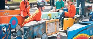In der Boxengasse. Am Sonntag wurde der Mehringdamm wieder zur Rennpiste. Mit rund 35 km/h sausten die Fahrer, immer im Dreier-Pulk, die 350 Meter lange Strecke hinunter. In den ersten Nachkriegsjahren hatten die Amerikaner die Tradition der Kreuzberger Seifenkistenrennen begründet. Foto: dpa