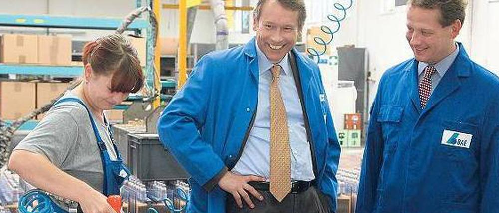 Detailarbeit. Dafür interessieren sich Senator Ulrich Nußbaum, parteilos, und IHK-Präsident Eric Schweitzer (rechts) beim Batteriehersteller BAE. Am Mittwoch besuchten sie mit SPD-Fraktionschef Raed Saleh mittelständische Unternehmen.