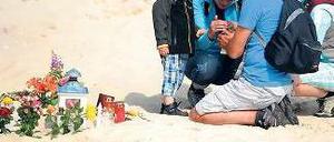 Gedenken. Eine Familie zündet in der Nähe des Unglücks eine Kerze an. Foto: dpa