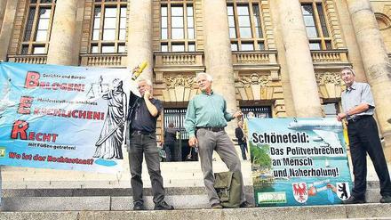 Demonstranten begleiteten das Verfahren mit Plakaten.