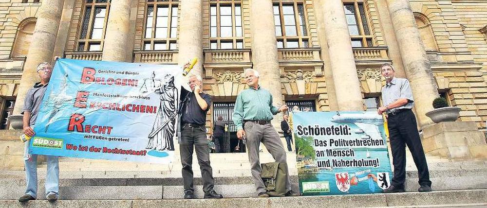 Demonstranten begleiteten das Verfahren mit Plakaten.