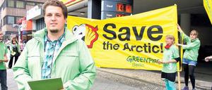 DIE WELT IST KLEIN. Greenpeace-Mitglied Martin Hausding, 28, Fernsehtechniker aus Steglitz, appelliert mit anderen Aktivisten vor einer Tankstelle an der Müllerstraße an Autofahrer, sie mögen wegen des CO2-Ausstoßes weniger fahren. 