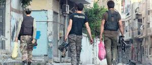 Im Kriegszustand. Mitglieder der syrischen Oppositionsarmee tragen Munition durch die Straßen der Stadt Homs. 