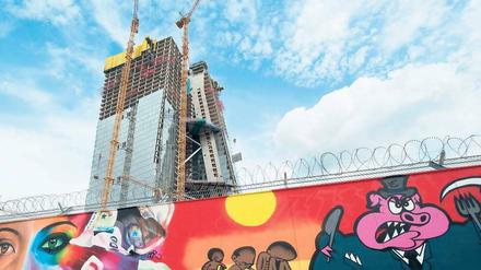 Kunst vorm Bau. Der Schutzzaun, der die Baustelle der neuen EZB-Zentrale umgibt, erinnert ein wenig an die Berliner Mauer – jedenfalls aus künstlerischer Sicht scheint er ähnlich attraktiv zu sein. Foto: dpa