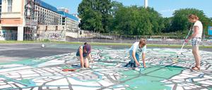 Weltstadt-Malerei. Junge Künstler aus Deutschland, Spanien, Frankreich und vielen anderen Ländern arbeiten auf dem Schlossplatz an einem Riesenplan von Berlin. Zur 775-Jahr-Feier soll er mit zahlreichen Beispielen dokumentieren, wie Einwanderer die Stadt zu dem gemacht haben, was sie heute ist. 