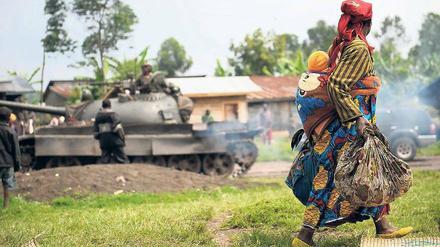Unschuldige Opfer. Eine Frau flieht mit ihrem Kind vor den Auseinandersetzungen von Regierungstruppen und Rebellen in der Demokratischen Republik Kongo.