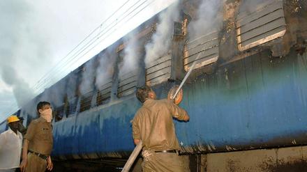 Helfer löschen das Feuer im Zugwaggon.