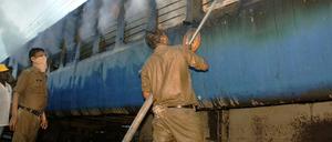 Helfer löschen das Feuer im Zugwaggon.