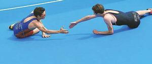 Habe die Ehre! Javier Gomez (links) gratuliert dem im Ziel kollabierten Alistair Brownlee zum Olympiasieg. Foto: dpa