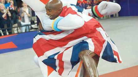Der Union Jack ist immer dabei. Mo Farah feiert mit Maskottchen Wenlock. Foto: AFP