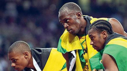 Drei aus der Nachbarschaft. Jamaika räumte alle Medaillen über 200 Meter ab: Hinter Bolt (M.) kamen Yohan Blake und Warren Weir (l.) ins Ziel. Foto: dpa