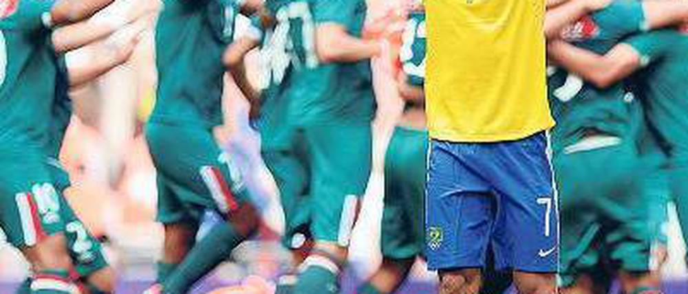 Gemeinsam und einsam. Während Mexikos Fußballer den Sieg bejubeln, ist Brasiliens Lucas untröstlich. Foto: dpa
