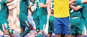 Gemeinsam und einsam. Während Mexikos Fußballer den Sieg bejubeln, ist Brasiliens Lucas untröstlich. Foto: dpa