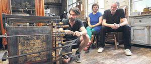 In der Schraubzwinge. Sonst leisten Restaurator Michael Wintjen (links) in seiner Friedenauer Werkstatt nur Möbel wie diese alte Truhe aus Myanmar Gesellschaft. Sonnabend lassen sich auch die Lesenacht-Organisatorin Sabine Würich und Schriftsteller Bernd Schroeder in seiner von Patina überzogenen Werkstatt blicken. Und natürlich die Zuhörer. 