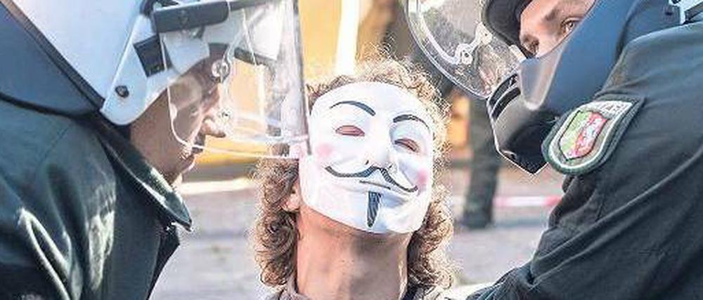Staatsmacht gegen Protestbewegung. Die Polizei trägt einen Aktivisten mit Maske Anfang August bei der Auflösung des Lagers in Düsseldorf fort.