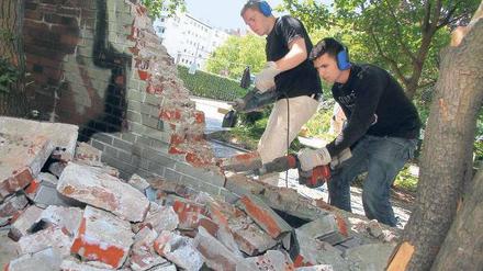 Einreißen, was die Sicht versperrt. Schüler des Oberstufenzentrums Bautechnik „Knobelsdorff-Schule“ begannen am Dienstag, mit Bohrhämmern eine Mauer am Bundesplatz abzutragen; das Entsorgen der Klinker übernehmen die Mitglieder der Anwohnerinitiative. Die will dem Platz wieder ein Gesicht verleihen, ihn reinigen und begrünen. 