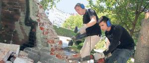 Einreißen, was die Sicht versperrt. Schüler des Oberstufenzentrums Bautechnik „Knobelsdorff-Schule“ begannen am Dienstag, mit Bohrhämmern eine Mauer am Bundesplatz abzutragen; das Entsorgen der Klinker übernehmen die Mitglieder der Anwohnerinitiative. Die will dem Platz wieder ein Gesicht verleihen, ihn reinigen und begrünen. 