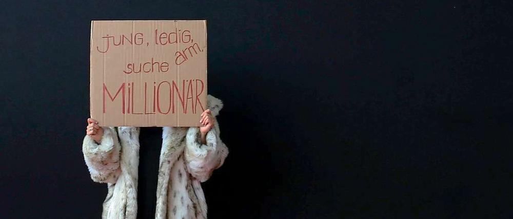 Klare Ansage. An das Geld der Millionäre will nicht nur diese junge Frau vor einer Luxusmesse in München. Die könnten aber bald ein bisschen weniger Geld haben. 