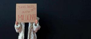 Klare Ansage. An das Geld der Millionäre will nicht nur diese junge Frau vor einer Luxusmesse in München. Die könnten aber bald ein bisschen weniger Geld haben.