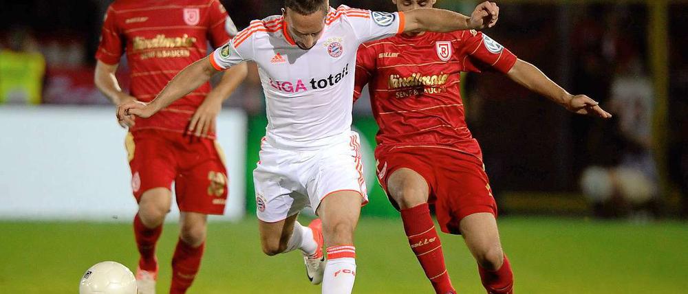 Münchens Franck Ribery (Mi.) gegen Regensburgs Abdenour Amachaibou (re.).