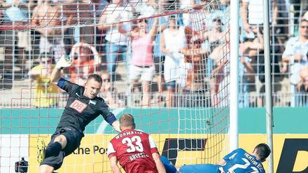 Ball drin, Hertha raus. Während der Wormser Romas Dressler (rotes Trikot) einen Konter erfolgreich zum Siegtreffer abschließt, dilettiert sich die Berliner Abwehr ins Pokal-Aus. Foto: Fishing4