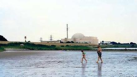 Das runde Ding (hinten) soll 2021 abgeschaltet werden. Der Elbstrand in Brokdorf mit Atomkraftwerk. 