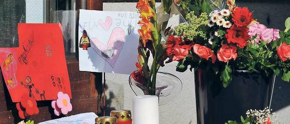 Stille Trauer. Blumen, Kerzen und Abschiedsbriefe vor dem Unglückshaus. F.: dapd
