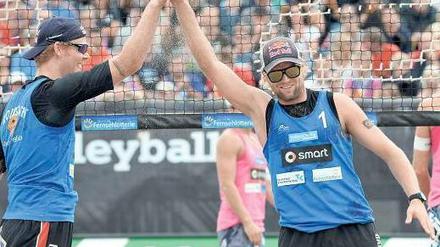 Klatschgeschichte. Julius Brink (rechts) und Jonas Reckermann müssen in Timmendorfer Strand nicht nur Beachvolleyball spielen, sondern auch sich selbst präsentieren. Ihr Manager sagt: „80 Interviews, 80 Mal die gleichen Fragen.“ Foto: dapd