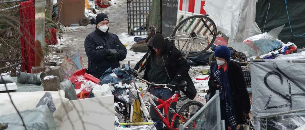 Obdachlose suchen ihre Sachen im aufgelösten Lager.