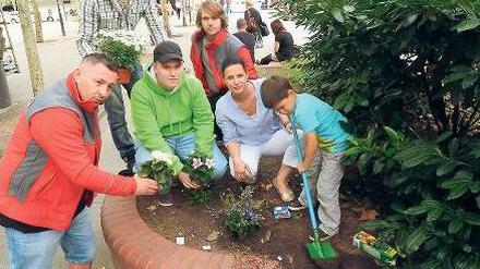 Blumengrüße vom Runden Tisch. Platzmanagerin Doreen Faber mit ihrem Sohn Jamie (vorne rechts), den Streetworkern Ümit Urkal und George Gerz (links und Mitte) sowie den jungen Steglitzer Aktiven Denis Andres und Marco Krause. 