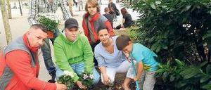 Blumengrüße vom Runden Tisch. Platzmanagerin Doreen Faber mit ihrem Sohn Jamie (vorne rechts), den Streetworkern Ümit Urkal und George Gerz (links und Mitte) sowie den jungen Steglitzer Aktiven Denis Andres und Marco Krause. 