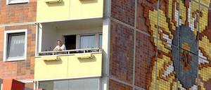 Ein Bewohner des "Sonnenblumenhauses" in Rostock-Lichtenhagen schaut den Protesten 