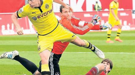 Schneller als der Ball. Der Dortmunder Robert Lewandowski (vorn) scheitert an Nürnbergs Torhüter Raphael Schäfer. Foto: dapd