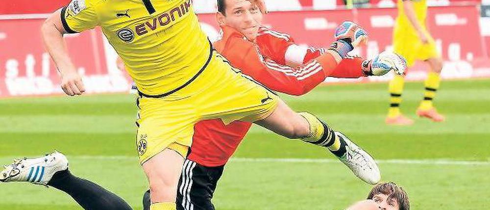 Schneller als der Ball. Der Dortmunder Robert Lewandowski (vorn) scheitert an Nürnbergs Torhüter Raphael Schäfer. Foto: dapd
