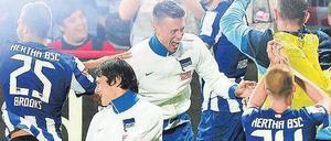 Wie im Rausch. Einige Hertha-Spieler bejubeln in der Kurve ihrer Fans den Sieg über Union. Foto: dpa