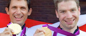 Die Olymiasieger Michael Teuber (l.) und Tobias Graf posieren mit ihren Gold-Medaillen nach ihrem Erfolg im Zeitfahren.