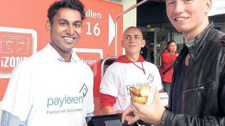 Ungewohnt. Der Verkäufer hält dem Kunden ein Tablet zur Unterschrift hin, damit dieser sein Ein-Euro-Würstchen bezahlen kann. Zuvor hat er seine Kreditkarte durch einen kleinen Plastikaufsatz an dem mobilen Computer gezogen. 