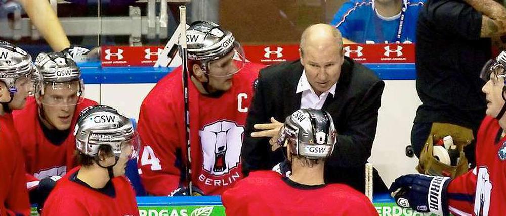 Berlins Trainer Don Jackson (2.v.r.), hier beim Spiel gegen die Hamburg Freezers, spricht während einer Auszeit mit seinen Spielern.