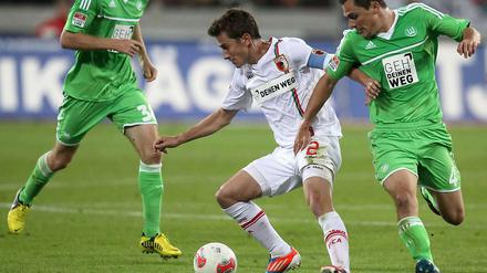 Vergebliches Duell um ein Tor. Augsburgs Paul Verhaegh (l) und Wolfsburgs Marcel Schäfer kämpfen um Ball und Sieg.