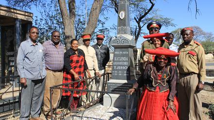 Angehörige der namibischen Volksgruppe der Herero stehen, teils in traditioneller Stammestracht, in der namibischen Stadt Okahandja am Grab eines verstorbenen Oberhäuptlings. 