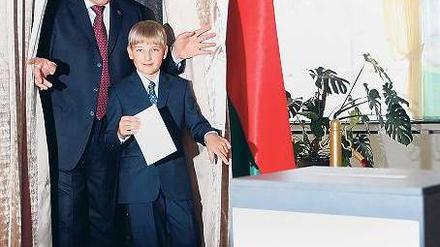 Lukaschenko kommt mit seinem jüngsten Sohn Nikolai aus der Wahlkabine