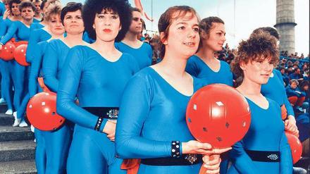 Frohsinn in Blau-Rot. Sportlerinnen vor dem Einmarsch ins Stadion der Weltjugend, Ost-Berlin, Pfingsten 1989. 