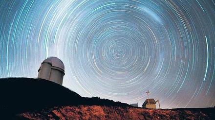Am Südpol. Die Langzeitbelichtung zeigt, wie Sterne über dem Observatorium La Silla um den südlichen Himmelspol kreisen. Dahinter steckt aber nicht etwa eine rasante Eigenbewegung der Sterne, sondern die Drehung der Erde, die zu diesem optischen Effekt führt.