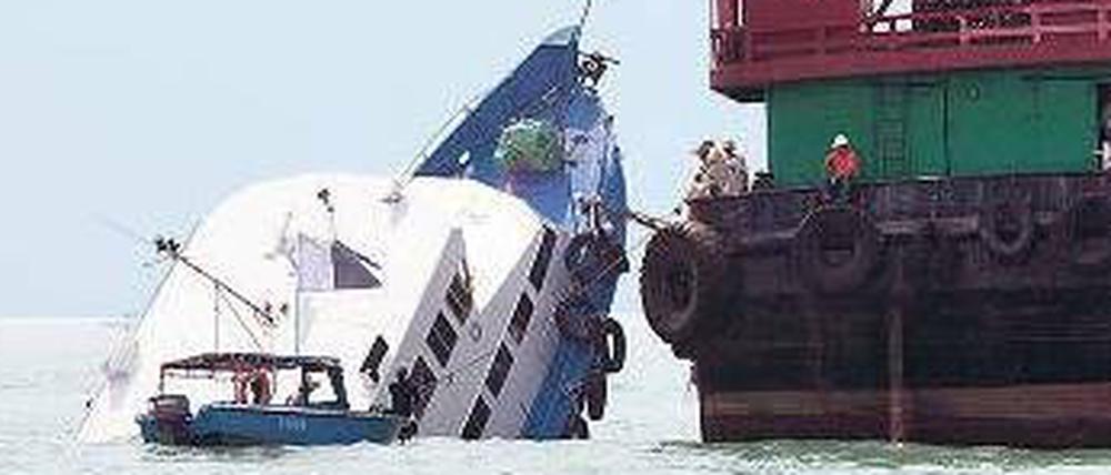 Ein Kran hebt das gesunkene Ausflugschiff aus dem Wasser. 