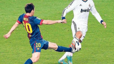 Zauberer am Werk. Messi (l.) und Ronaldo buhlen um die Gunst des Balls. Foto: dpa